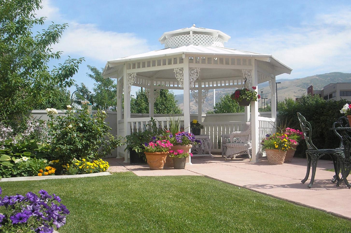 White gazebo surrounded by manicured lawn